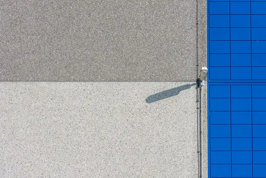 A modern building facade with solar panels and a security light, showcasing clean lines and textures.