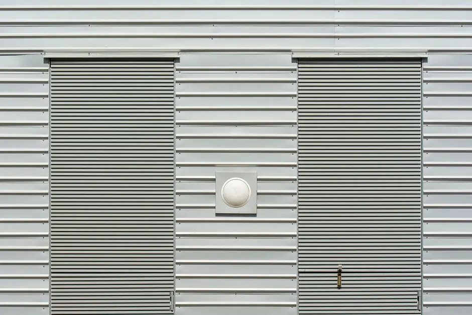 Close-up of a modern industrial building with metal siding and roller doors.
